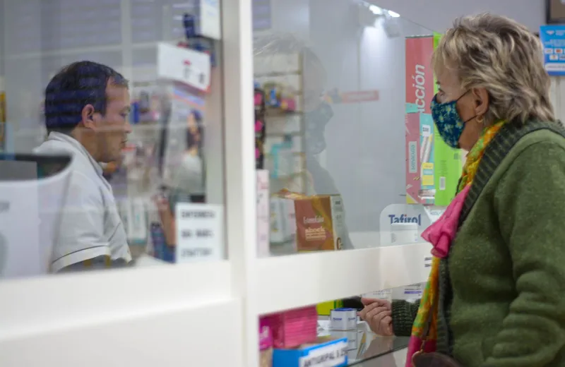 Customer speaking with a pharmacist at a pharmacy counter